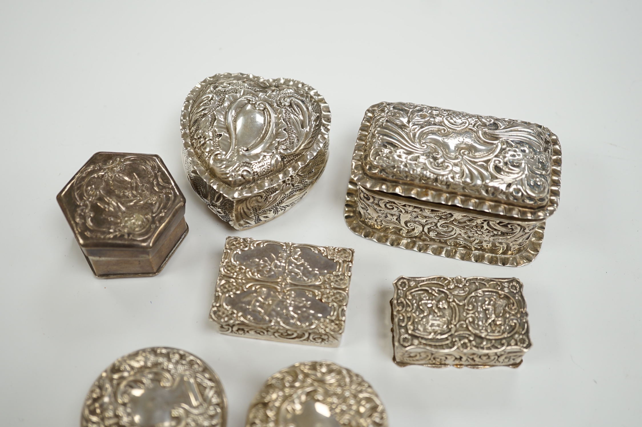 Six assorted early 20th century and later repousse silver boxes, largest 75mm and one similar white metal box.